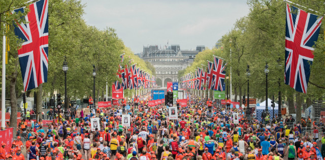 Marathon runners on The Mall in London with Union Jack flags overhead